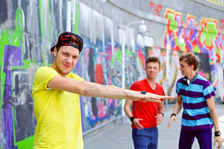 三个年轻朋友幸福快乐季节团队涂鸦青少年公司男生蓝色小伙子衣服街道图片