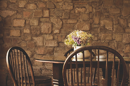 古老的椅子和有花的桌椅休息花束装饰家具座位房间古董风格桌子装饰品图片