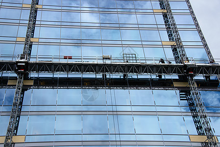 在摩天大楼上做假工作高楼脚手架高层建筑玻璃办公室办公楼城市建筑团块反思图片