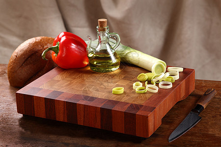 切菜板上的蔬菜植物油洋葱红色面包烹饪胡椒玻璃瓶食物厨房木头图片