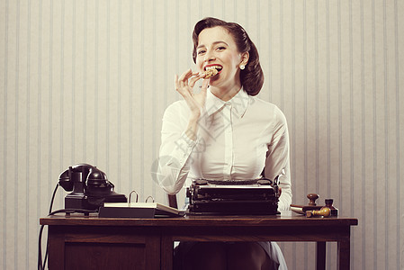 女商务人士吃曲奇饼商务饼干电话打字机桌子微笑食物人士复兴女子图片