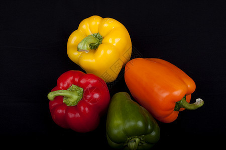 黑色背景的多彩辣椒白色阴影红色厨房种子绿色胡椒蔬菜橙子黄色图片