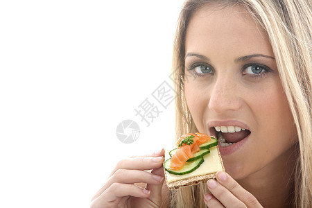 女青年在奶酪饼干上吃烟熏沙门鱼的乳酪小吃微笑饼干头发金发女郎黄瓜白色女士图片