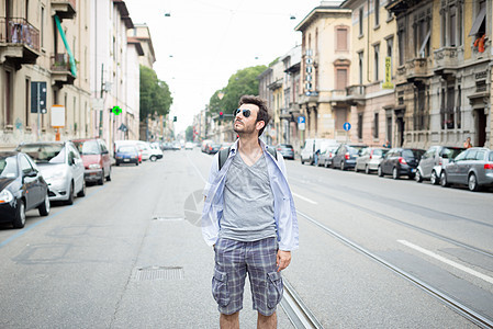 男人在街上行走太阳镜日常生活城市生活胡子城市游客街道背景图片