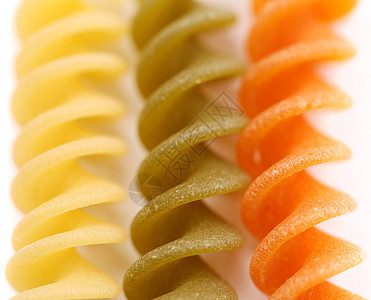 近乎接近的意大利面螺旋派对食物绿色三色营养品饺子橙子面条黄色背景图片