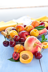 桃子和樱桃的种类繁多蓝色杯子篮子杏子水果树叶油桃照片图片