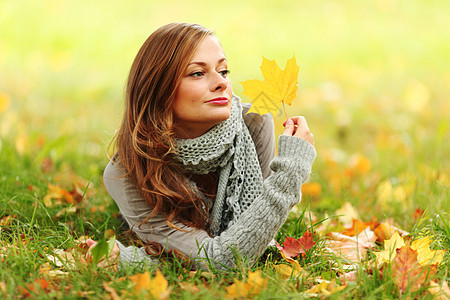 秋叶中的妇女脚尖女士感恩公园头发毛衣季节女孩眼睛乐趣橙子图片