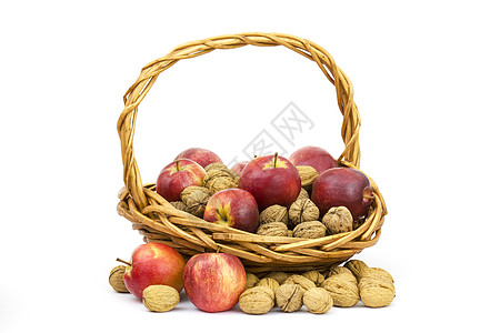 圣诞节苹果装满一篮子胡桃和苹果小吃核心季节性坚果白色健康帆布红色食物水果背景