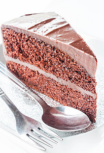用勺子和叉子把巧克力蛋糕贴上图片