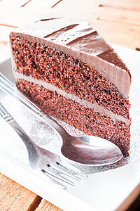 一块巧克力蛋糕 配汤匙和叉子图片