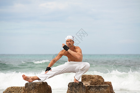 在沙滩夏天做静脉瑜伽冥想的 健康人蓝色海滩成人男人精神姿势平衡训练天空专注图片