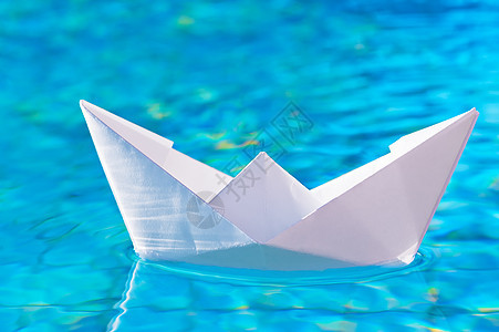游泳池中水面上的纸船图片