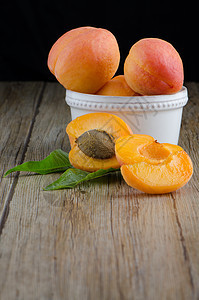 木桌上的杏子黄色桌子甜点橙子水果木板宏观维生素种子植物图片