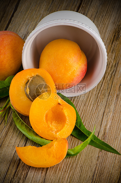 木桌上的杏子白色植物桌子黄色木板宏观种子叶子橙子水果图片
