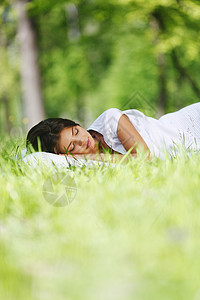睡在草地上的女人毯子白色公园女性场地绿色女孩枕头自由睡眠图片