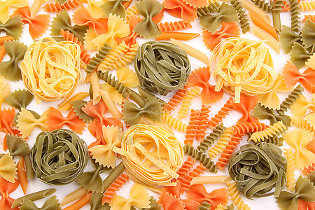 不同面食背景的 Dagliolini橙子面条派对黄色食物三色营养品绿色螺旋饺子背景图片