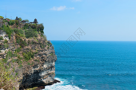 蓝热带海上岩石上的树丛寺庙海景风景海岸线爬坡宗教海浪悬崖海岸蓝色海洋图片