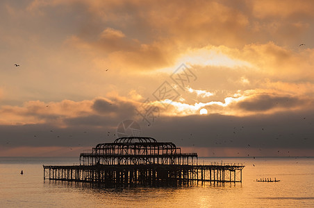 日落时西码头建筑太阳海岸地标海洋建筑学戏剧性天空海滩金属图片