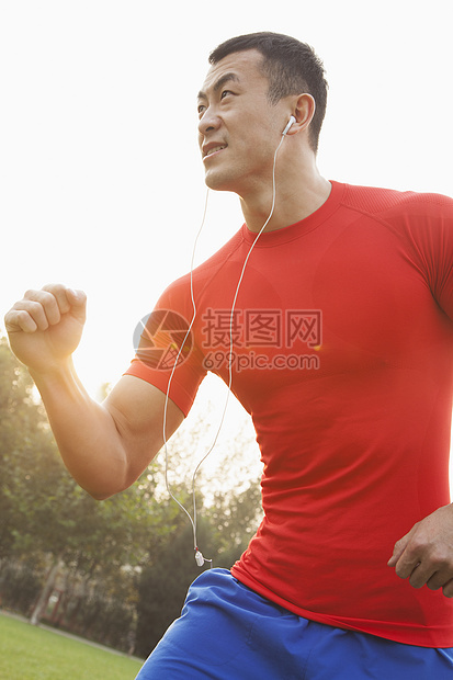 跑步和听音乐的肌肉人公园力量音乐活力黑发微笑耳机耀斑摄影衬衫图片