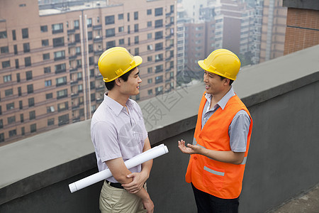 建筑师和建筑施工工人在屋顶上交谈两个人商务同事摩天大楼愿望职业天际听力合作检查图片