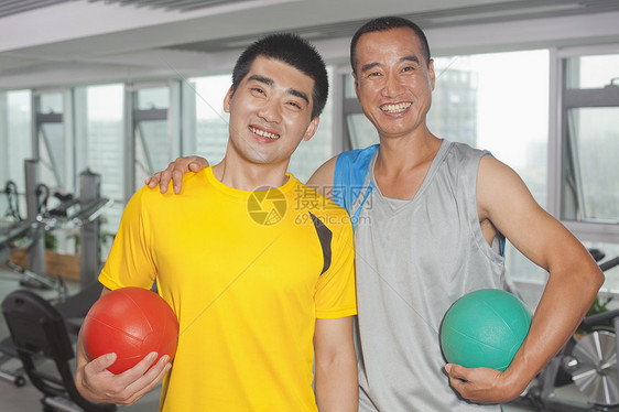 两个男人在健身房里拿着球图片