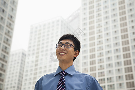 微笑着看着天空的年轻商务人士图片