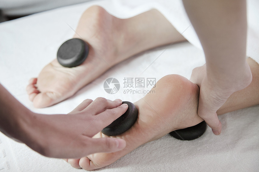 接受热石脚按摩的妇女活力呵护人体平衡生活方式石头药物医疗职业摄影图片