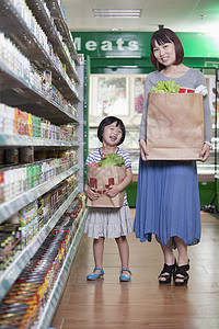 母亲和女儿在北京超级超市持有杂货袋摄影购物喜悦休闲棕色架子商业走道健康饮食零售图片