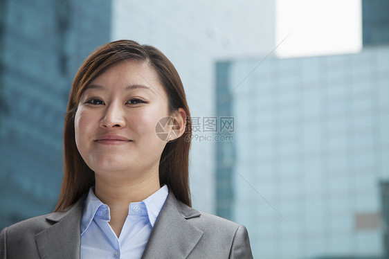 摩天大楼户外年轻女商务人士的肖像长发业务活力棕色套装摄影幸福头发前景建筑图片