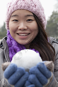 带雪球的年轻女子围巾低温头肩休闲衣物享受服装摄影幸福乐趣图片