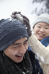 有雪球打斗的年轻夫妇年轻人低温行动女性微笑男朋友针织帽俏皮团结幸福图片