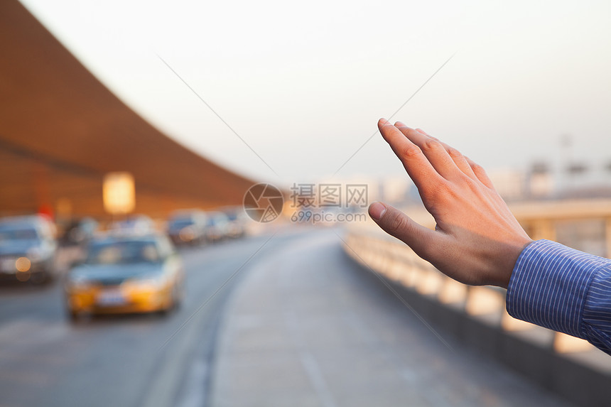 旅行者手中在机场外面叫出租车的手图片