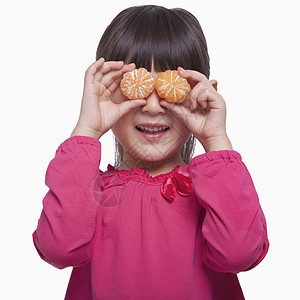 小姑娘当着她的眼睛 拿着普通话 摄影棚拍的镜头健康饮食服装收腰刘海粉色微笑童年女孩们享受棕色图片