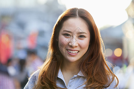 北京南卢国香市的微笑女青年幸福露齿休闲街道服装女性长发城市摄影前景图片