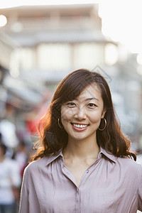 北京霍海的 微笑的成年中年少女肖像前景耳环休闲街道卷发长发女性服装纽扣衬衫图片