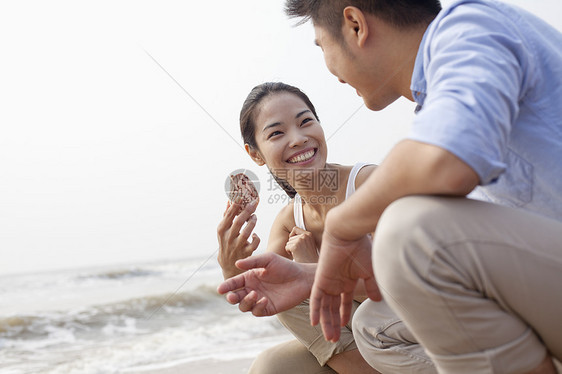 看着海边贝壳的年轻夫妇 中国水域边缘倾斜黑发微笑年轻人旅游享受假期短发女朋友团结图片