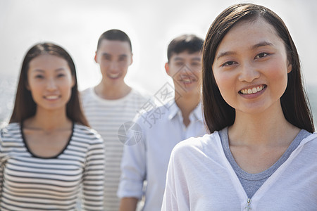 年轻女性的肖像和海滩上的朋友服装年轻人黑发头肩前景活动自由四个人旅行休闲图片