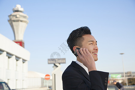 机场外面旅行者用手机聊天的旅客图片