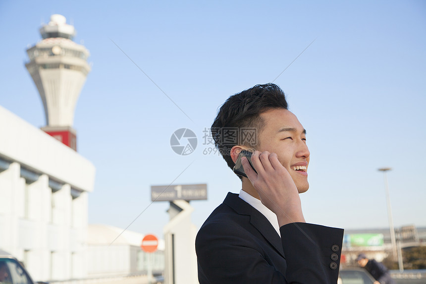 机场外面旅行者用手机聊天的旅客图片