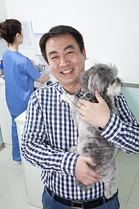 在兽医办公室有宠物狗的男人图片