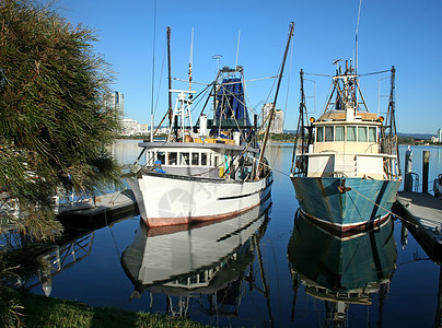 在码头的渔船船阳光蓝色索具天空外表船体反思风景海景船尾图片