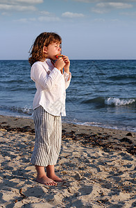 美丽的小女孩在沙滩上打锅炉管图片