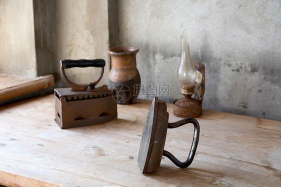 旧的铁 油灯和桌子上的罐头金属工具家政静物阳光水泥家庭熨烫家务水壶图片