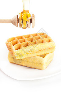 比利时的华夫饼放在盘子上 粘贴蜂蜜和蜂蜜液体早餐小吃美食食物棍棒蛋糕饼干晶圆甜点图片