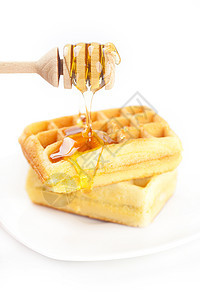 比利时的华夫饼放在盘子上 粘贴蜂蜜和蜂蜜棍棒环境晶圆食物小吃蛋糕液体午餐糕点饼干图片