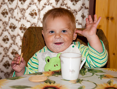 小男孩在桌边喝酒健康童年杯子快乐早餐桌子婴儿眼睛男孩们饮料图片