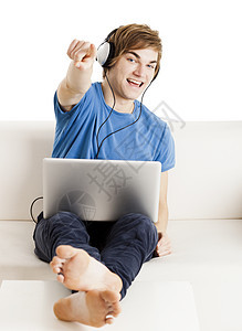 在沙发上快乐的男人蓝色互联网工作青少年技术乐趣爱好享受耳机衬衫图片
