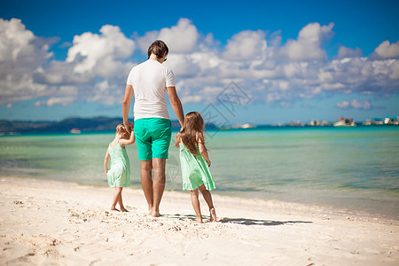 年幼的父亲和两个小孩在海边散步父母幸福情调女孩爸爸乐趣热带家庭女儿海岸线图片