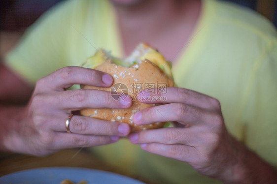 把汉堡包放在男人的手里吃早餐图片