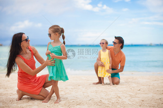 妈妈和大女儿在沙滩上 爸爸和小女儿在沙滩上异国海滩乐趣家庭女性海洋热带旅游婴儿孩子图片